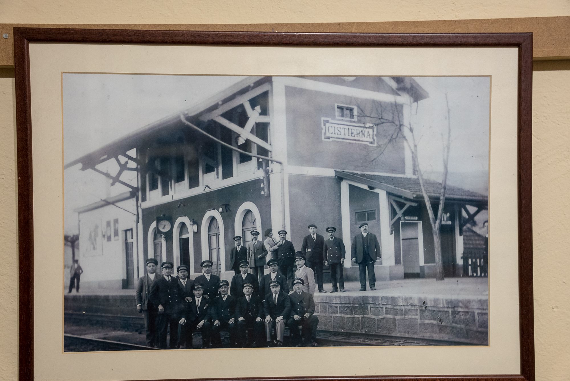 Fotografía histórica enmarcada de un grupo de ferroviarios ante la estación de Cistierna