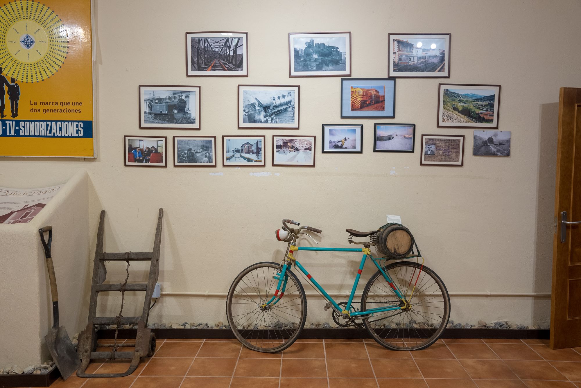 Bicicleta con bidón en el portaequipajes, carretilla de mano y pala