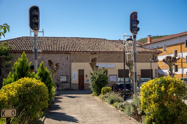 Camino del jardín hacia el museo, enmarcado por dos señales de luces y arbustos.